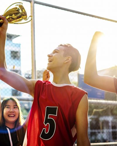 Group of teenagers cheering with trophy victory and teamwork concept