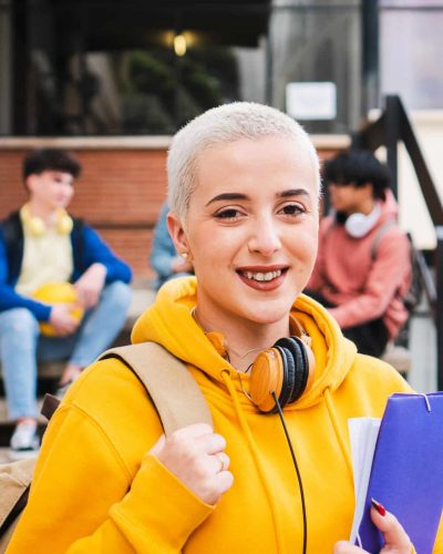 Young girl with short hair student looking at camera in campus - High Quality Photo